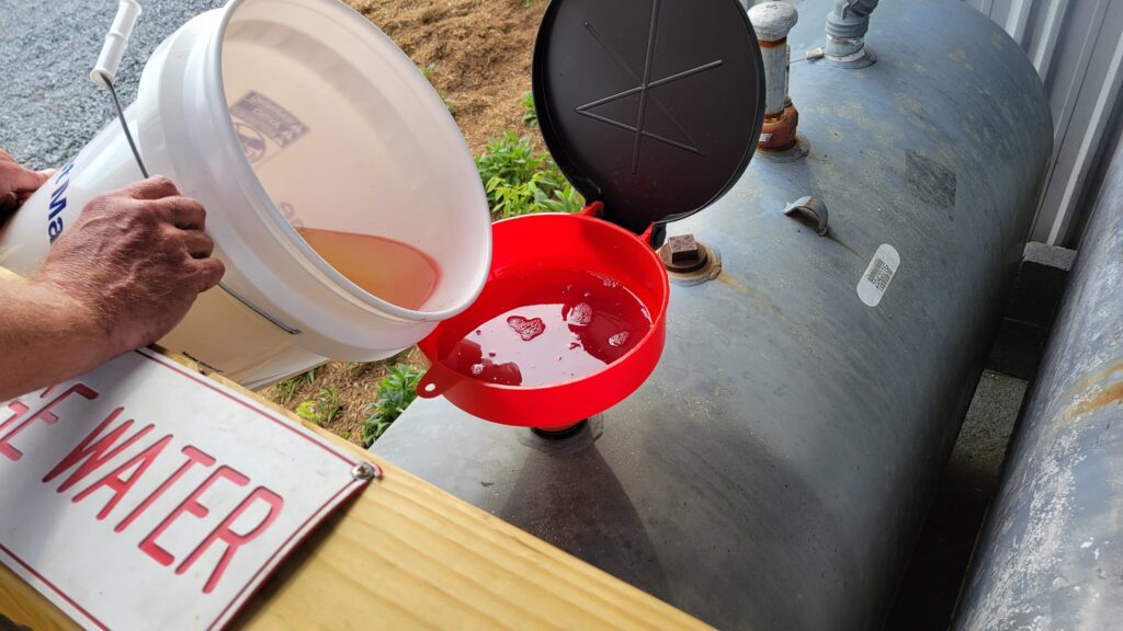 Pouring water mixed with a bit of diesel into the appropriate disposal area.